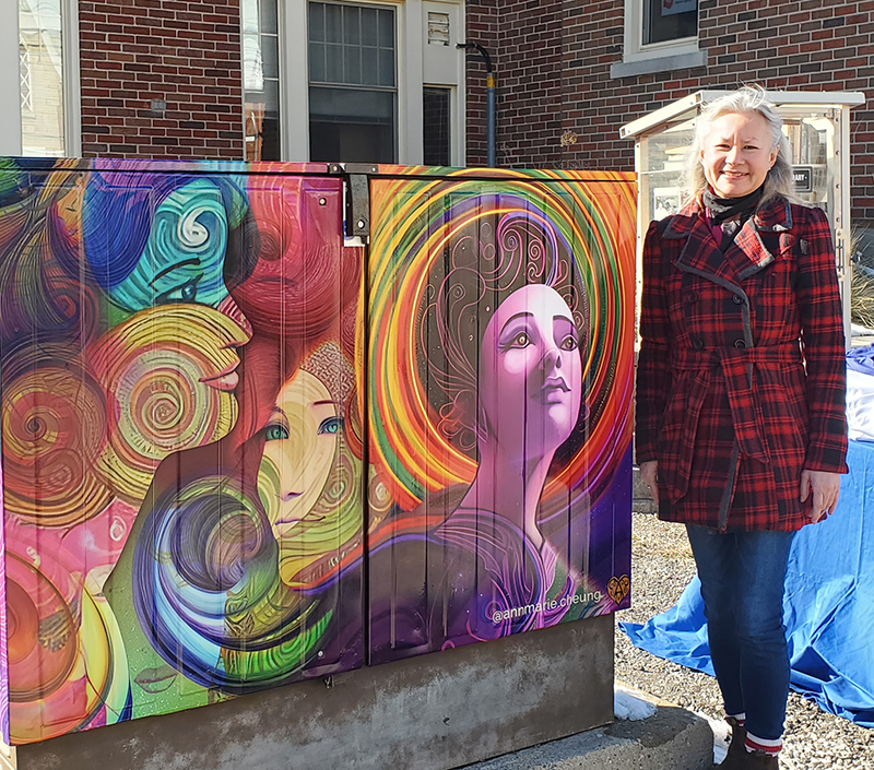 Ann-Marie Cheung standing in front of A Brighter Future mural